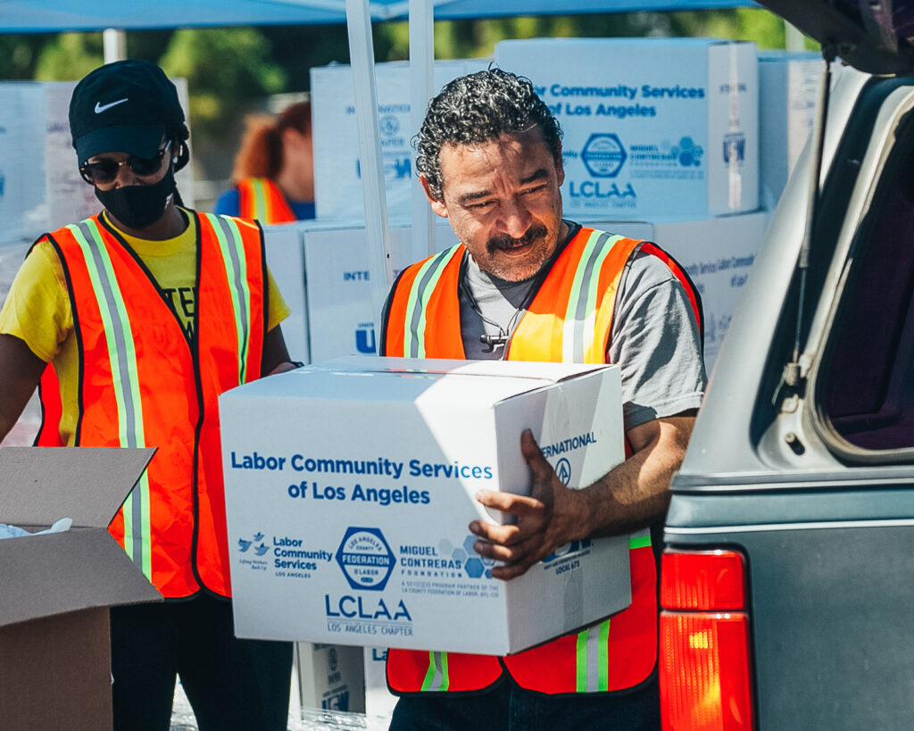 Two people carrying boxes of supplies.