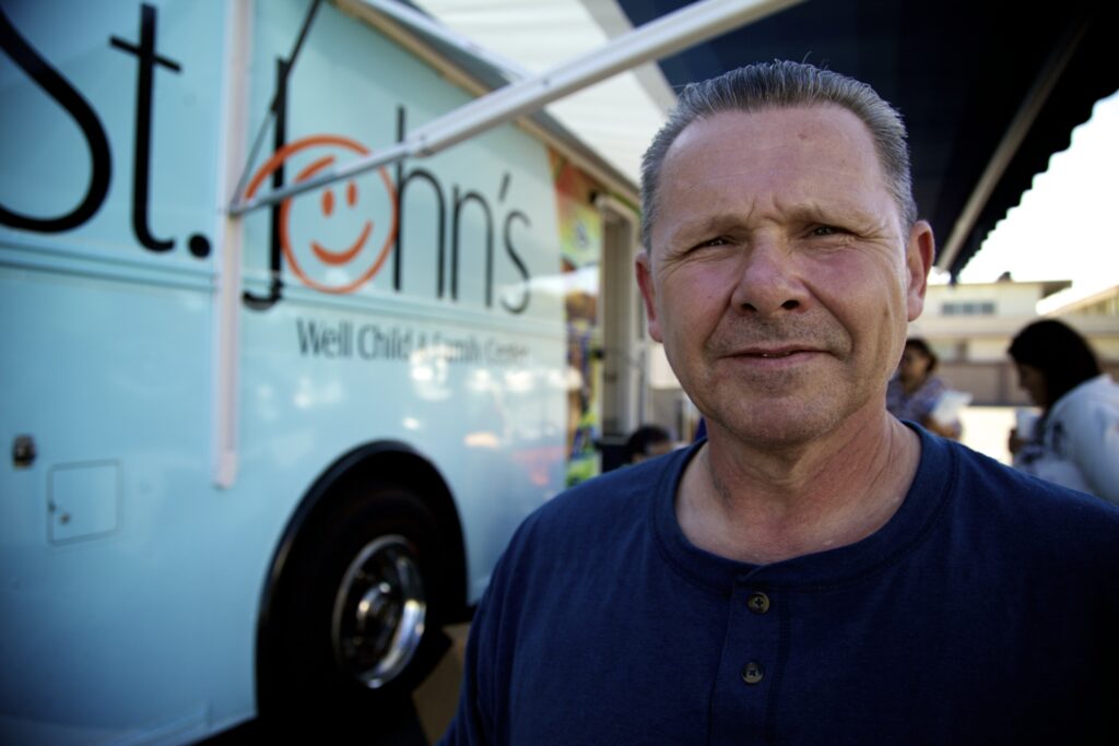 Patient standing in front of mobile health clinic