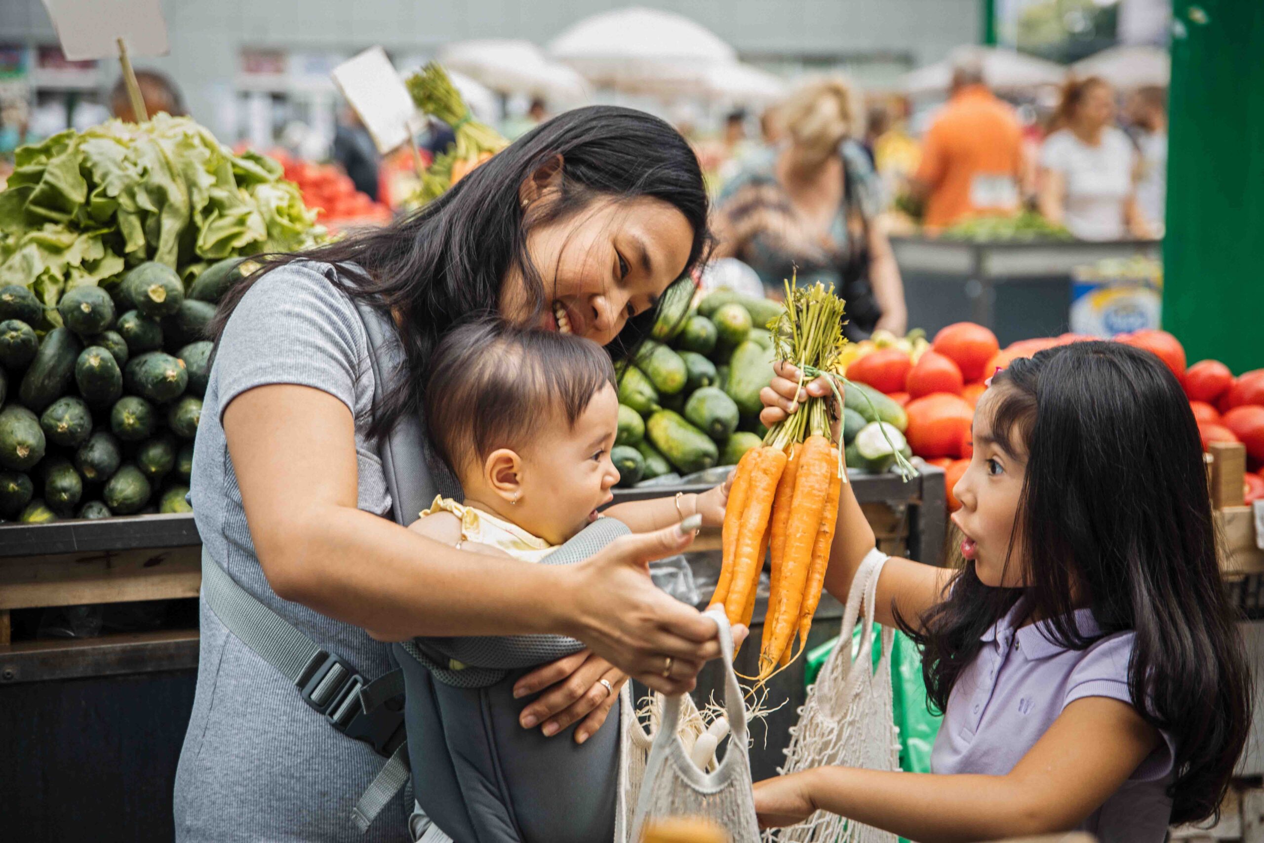 family putting carrots in grocery cart