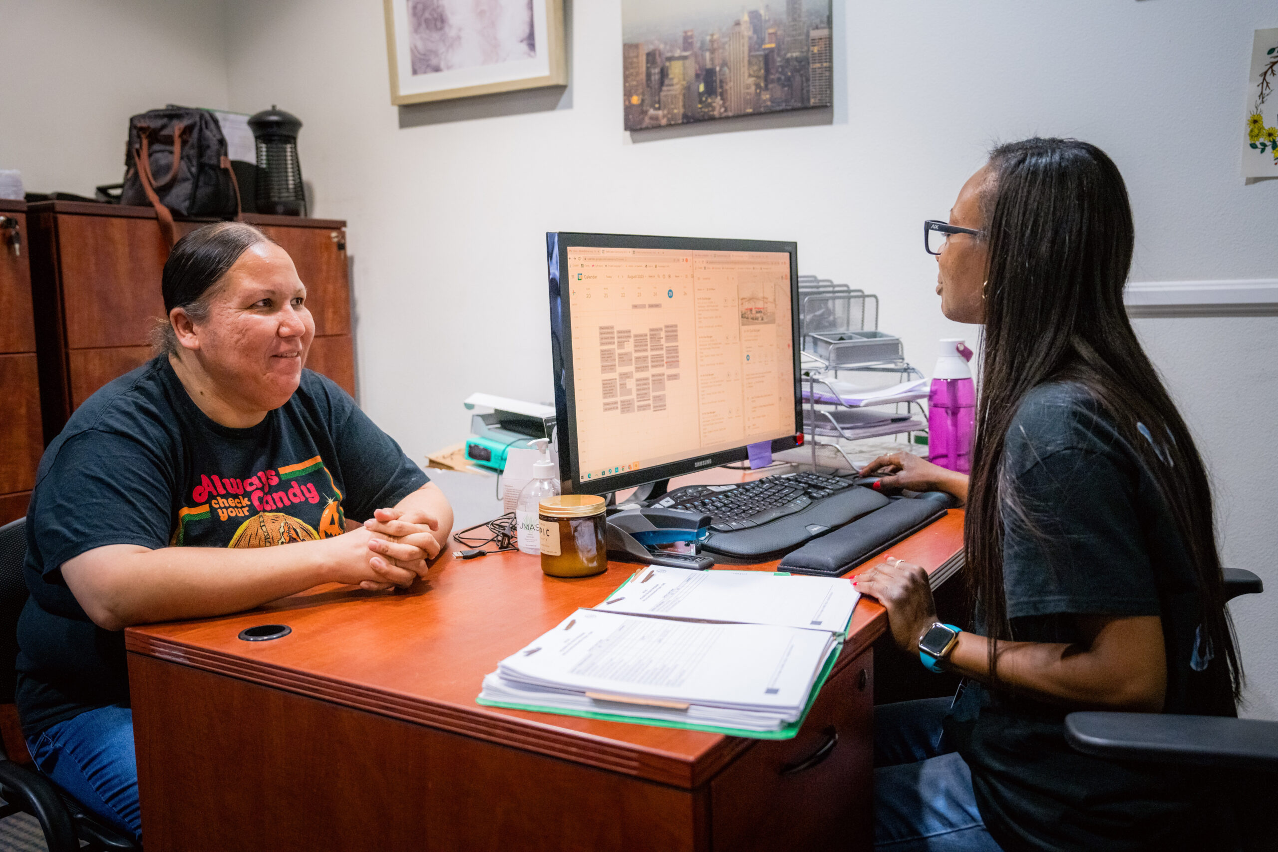 women helping another woman at desk